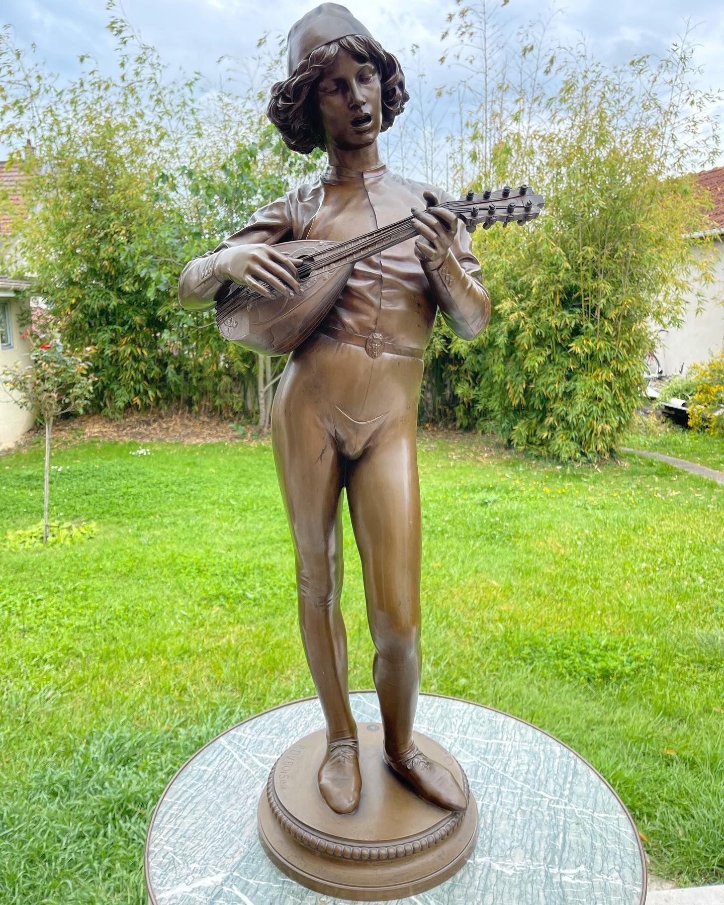 Sculpture d'une figure nue assise, les bras levés, en terre cuite.