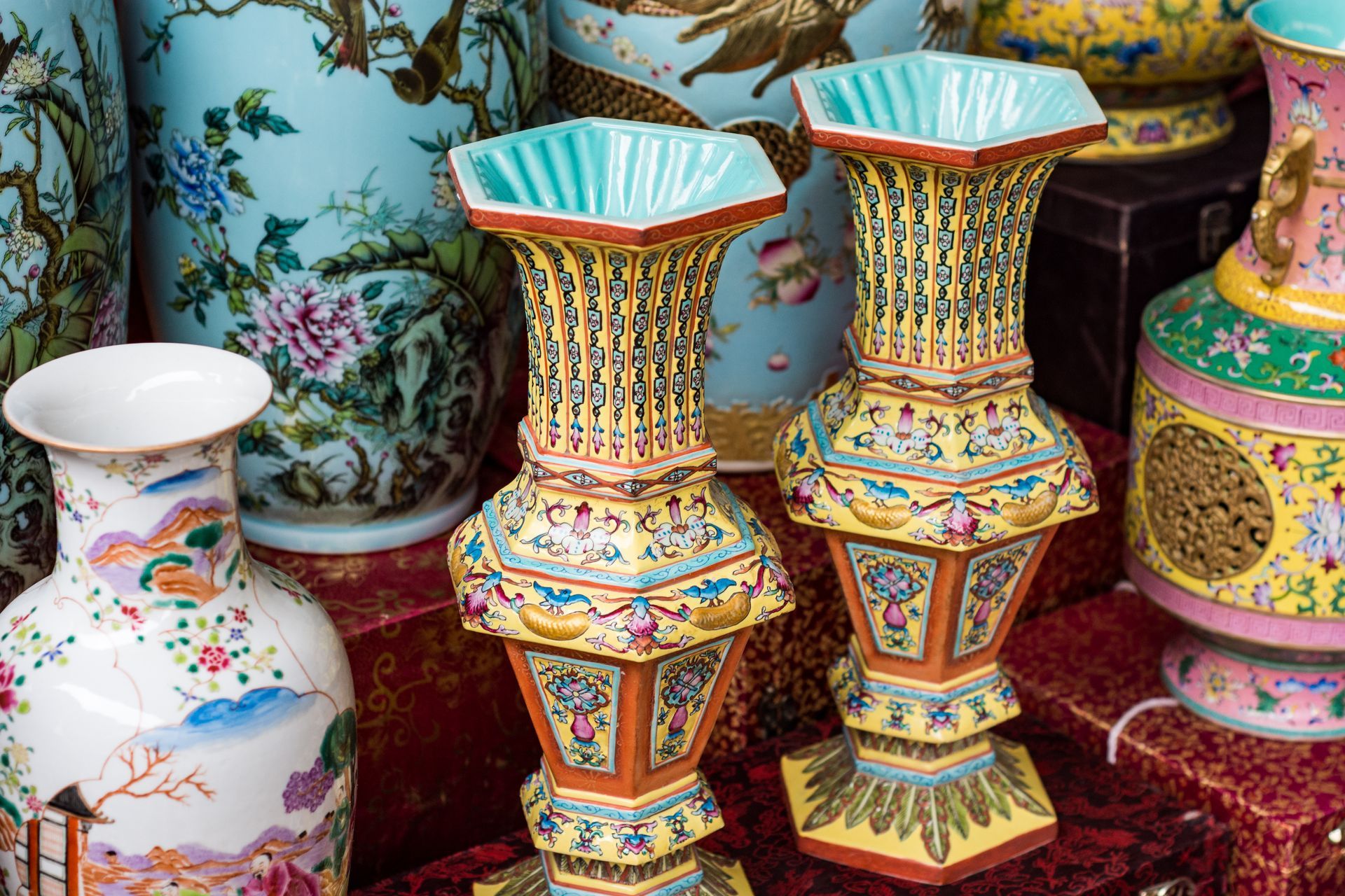 Collection de vases en céramique ornés et colorés, aux motifs complexes, probablement d'origine asiatique.