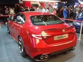 Alfa Romeo Giulia rouge exposée lors d'un salon automobile, vue arrière avec des personnes en arrière-plan