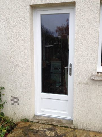 Une porte d'entrée blanche avec une large vitre