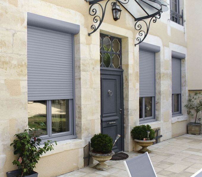 Une fenêtre avec des volets gris