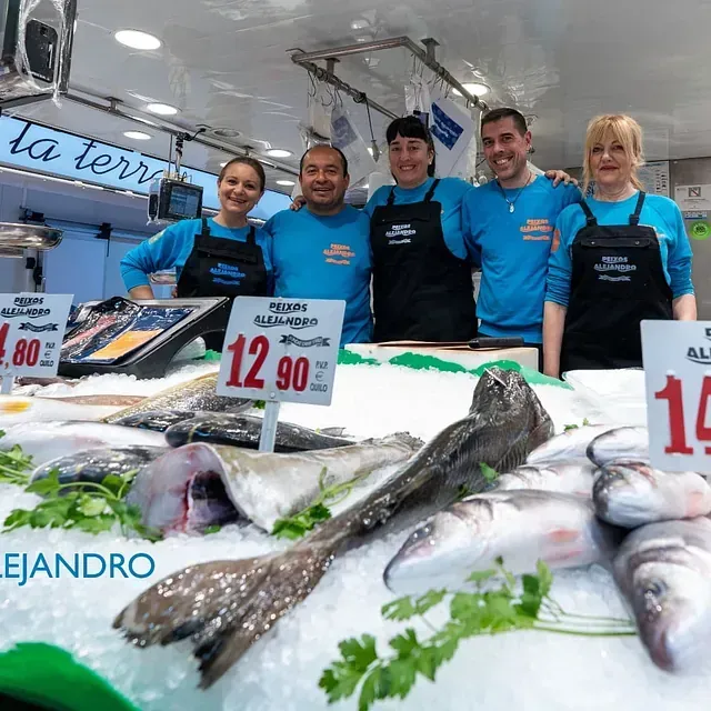 Un grupo de personas posa para una foto frente a un mercado de pescado.