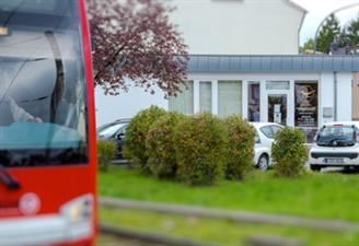 Ein roter Bus parkt vor einem Gebäude.