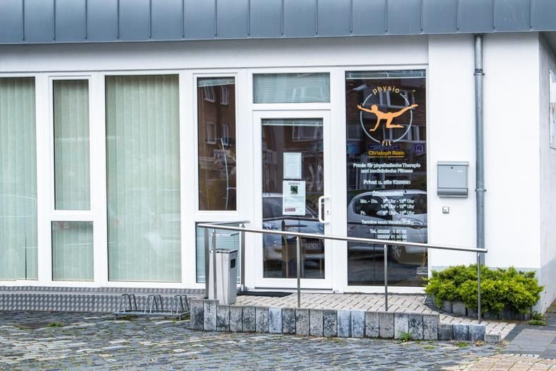 Die Eingangstür eines Gebäudes, zu der eine Rampe für Behinderte führt.