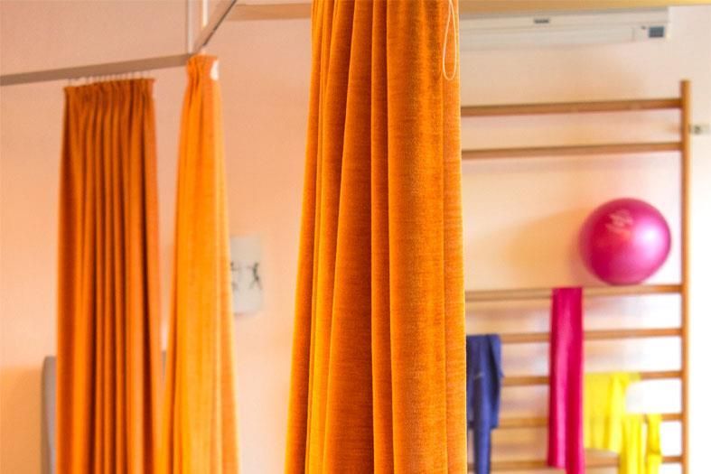 Ein Zimmer mit orangefarbenen Vorhängen und einem rosa Ball an der Wand