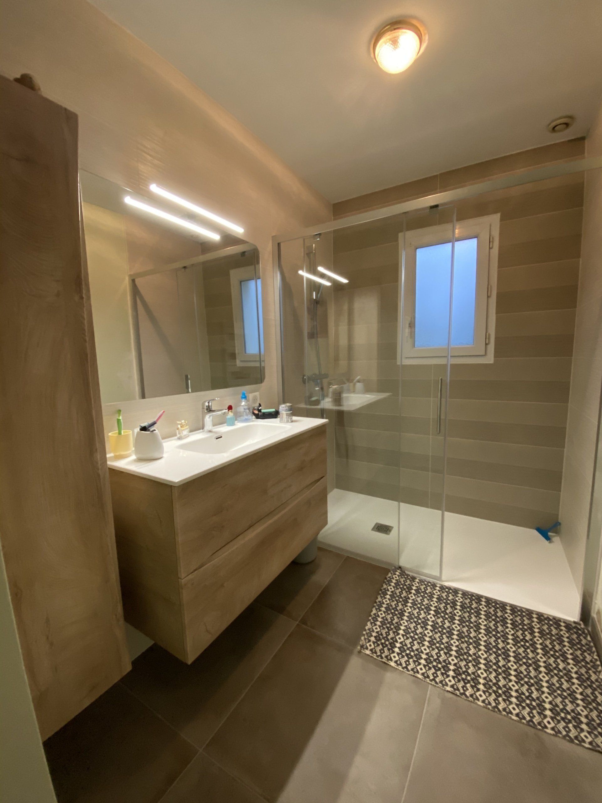 Salle de douche Grand meuble avec simple vasque et plage de chaque coté