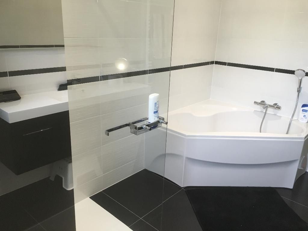 Salle de bain avec grande douche et baignoire d'angle