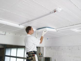 Deckenleuchte wird von einem Handwerker montiert