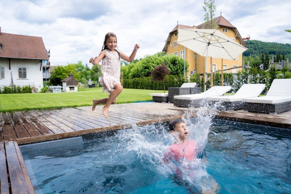 Kinder springen in einen Pool