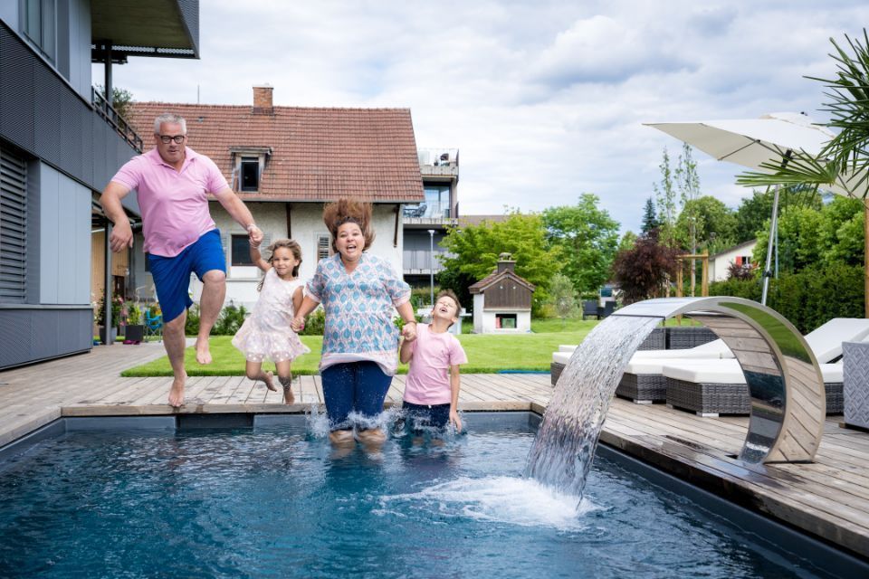 Vier Personen springen in einen Pool