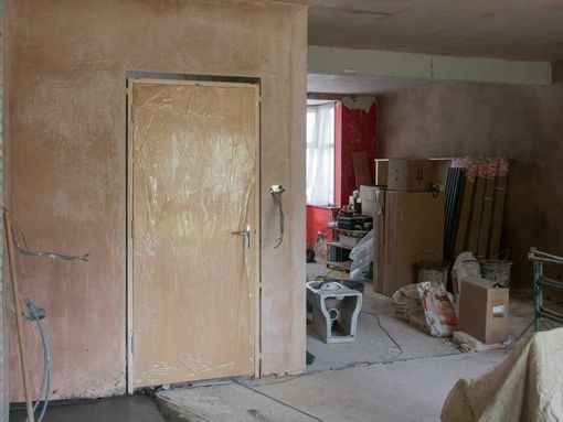 Una habitación con una puerta y cajas en el suelo.