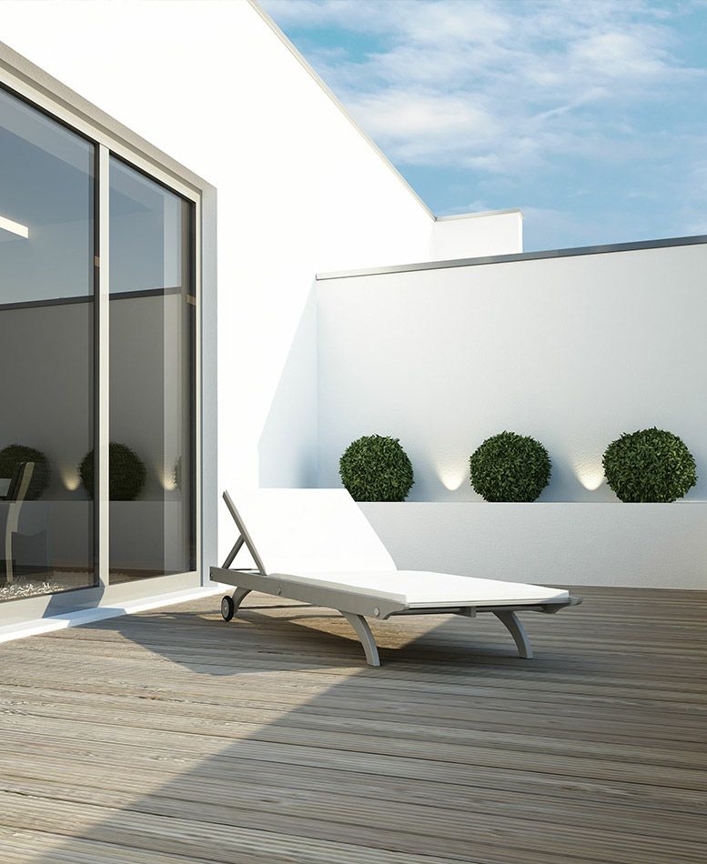 Terrasse en bois devant la baie vitrée d'une maison