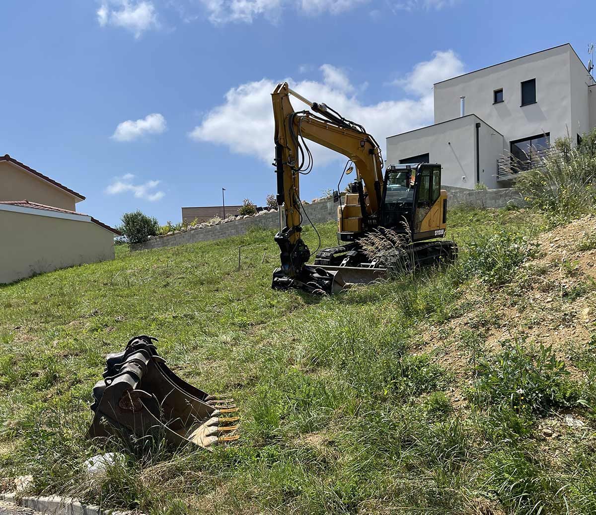 Pelleteuse sur un terrain herbeux en pente