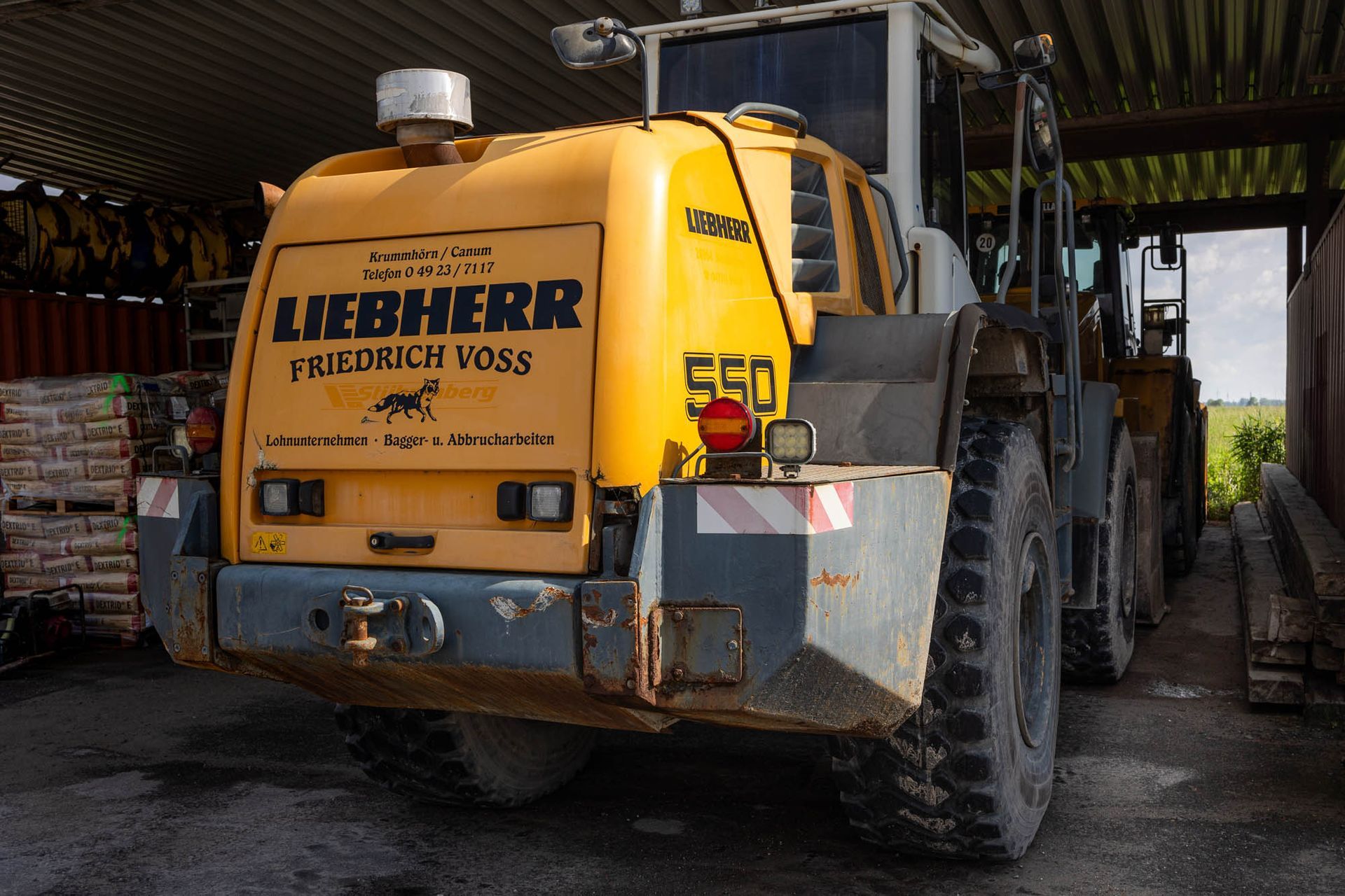 Ein gelber Liebherr-Traktor steht in einer Lagerhalle