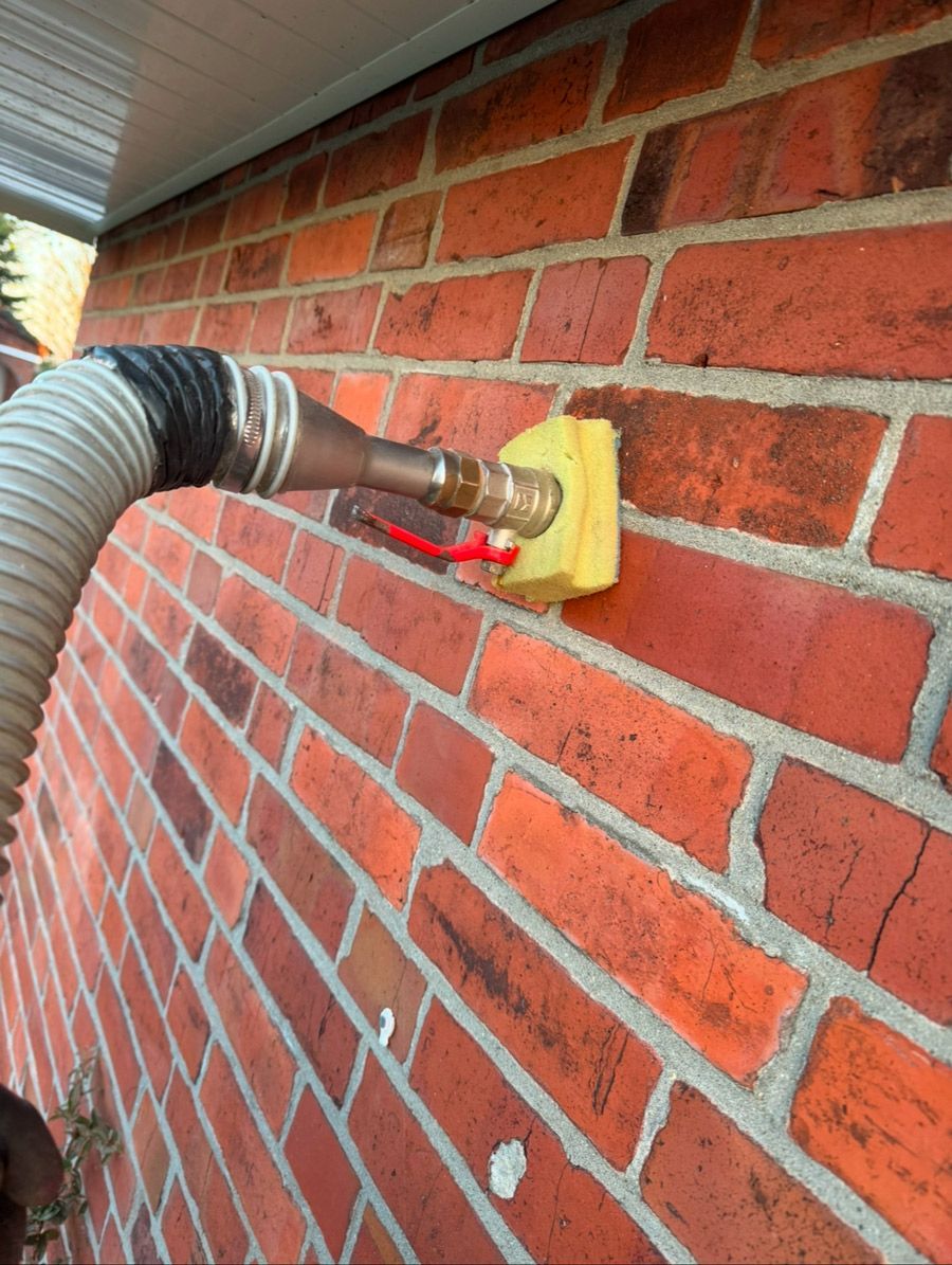 Eine Ziegelwand mit einem daran befestigten Schlauch