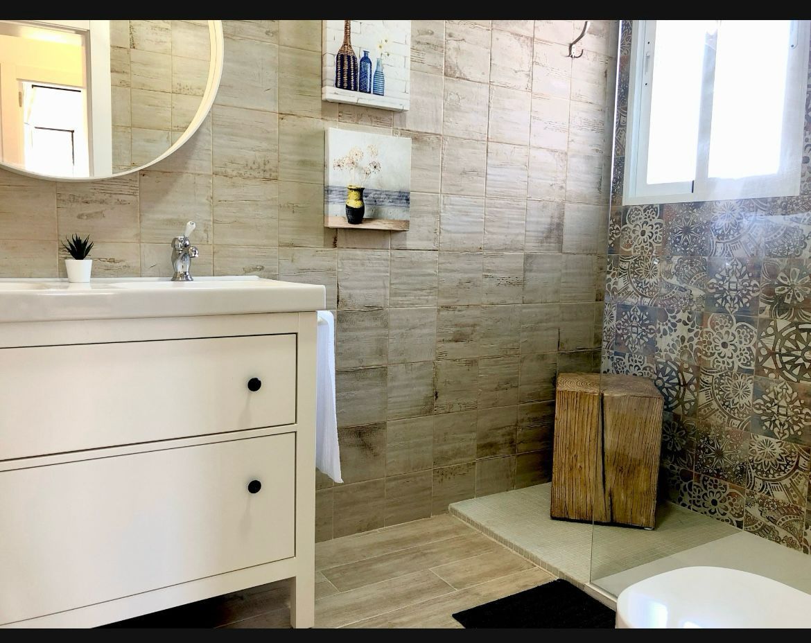 Un baño con lavabo, inodoro y espejo.