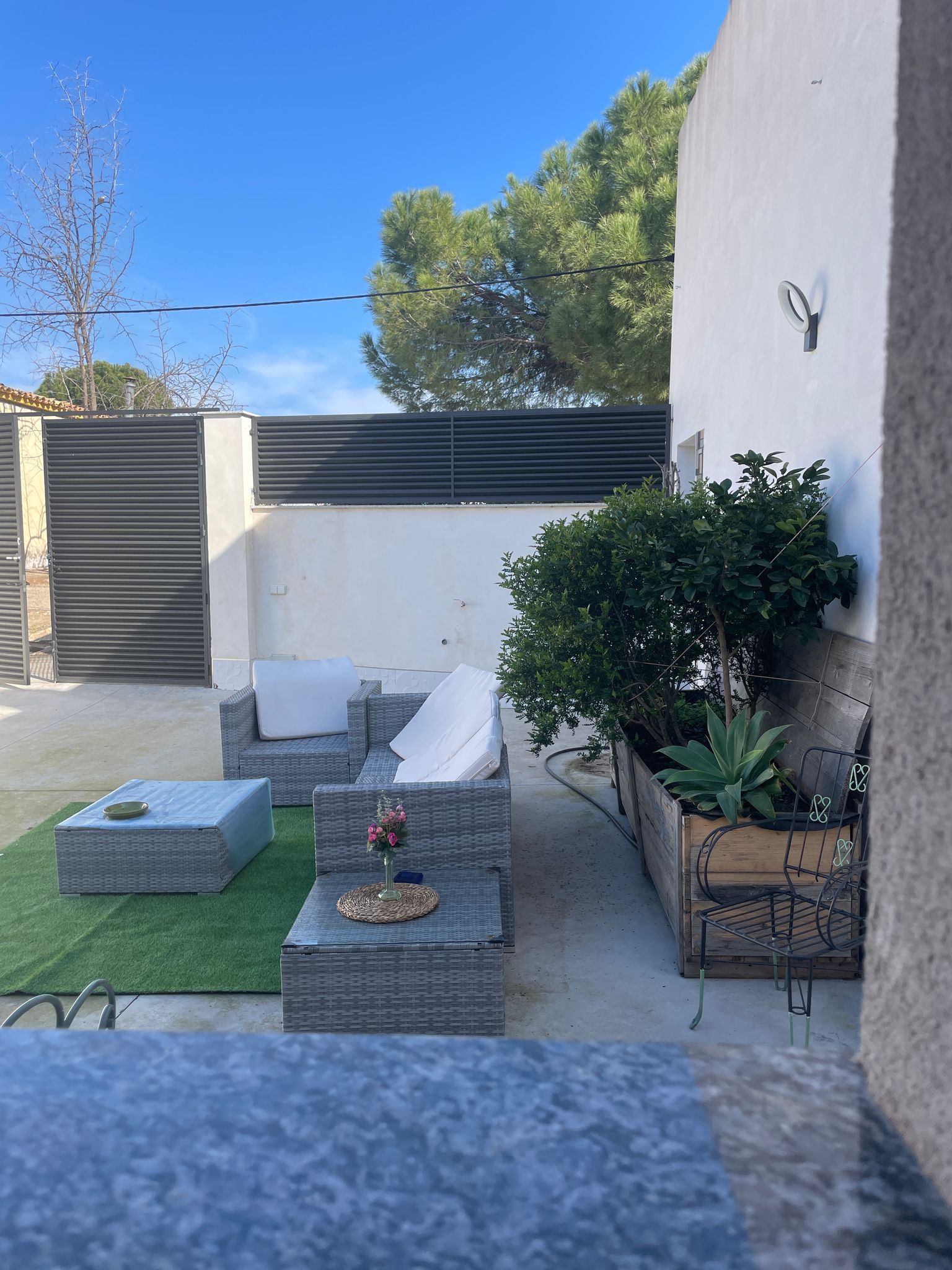 Un patio con un sofá, sillas y una mesa.