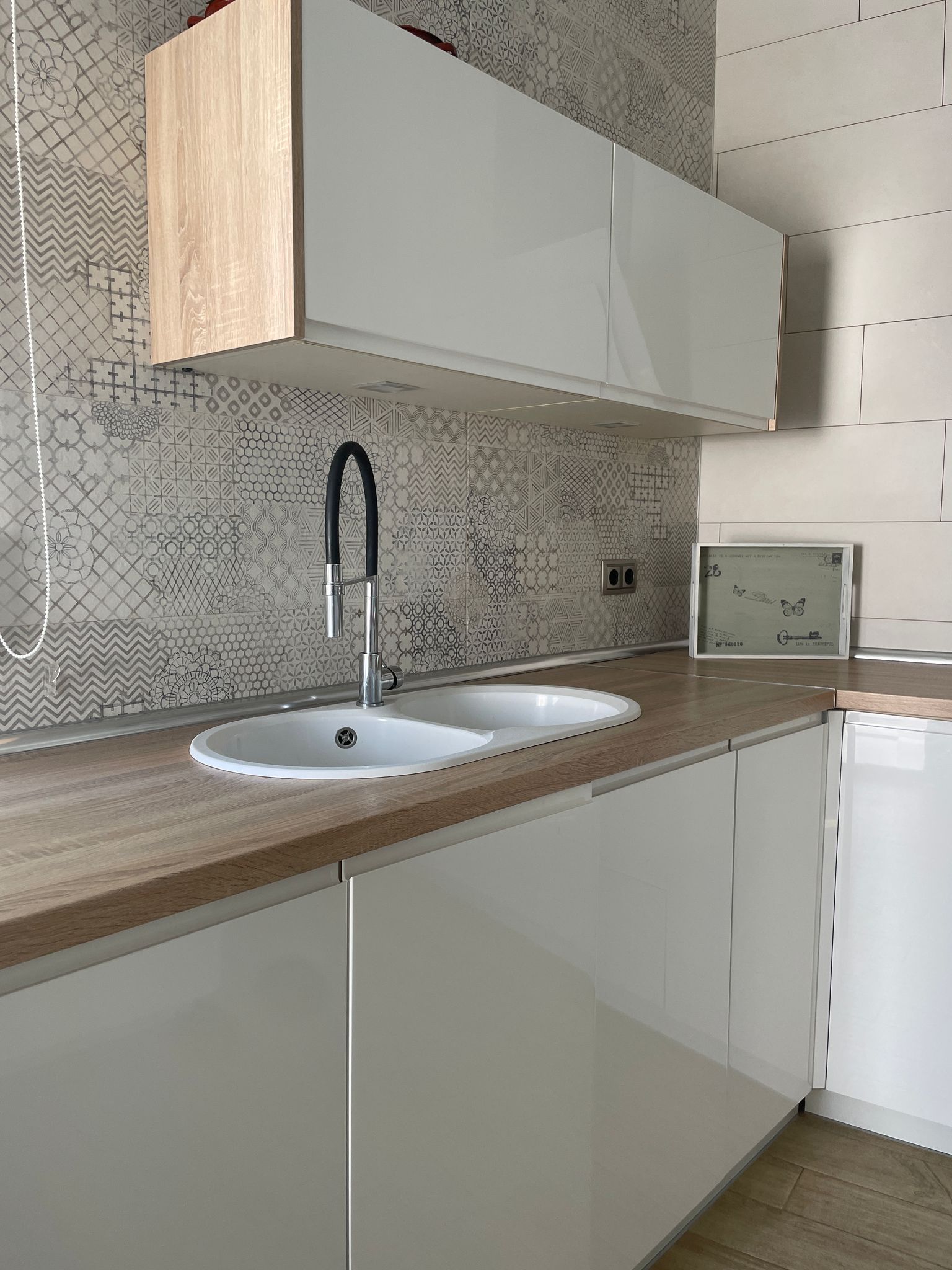 Una cocina con dos fregaderos y un reloj en la encimera.