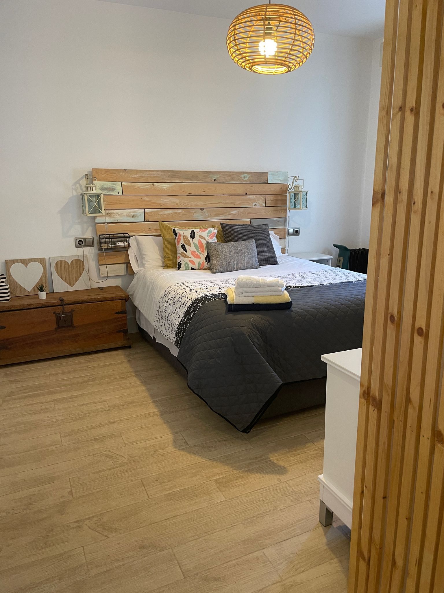 Un dormitorio con una cama y un cabecero de madera.