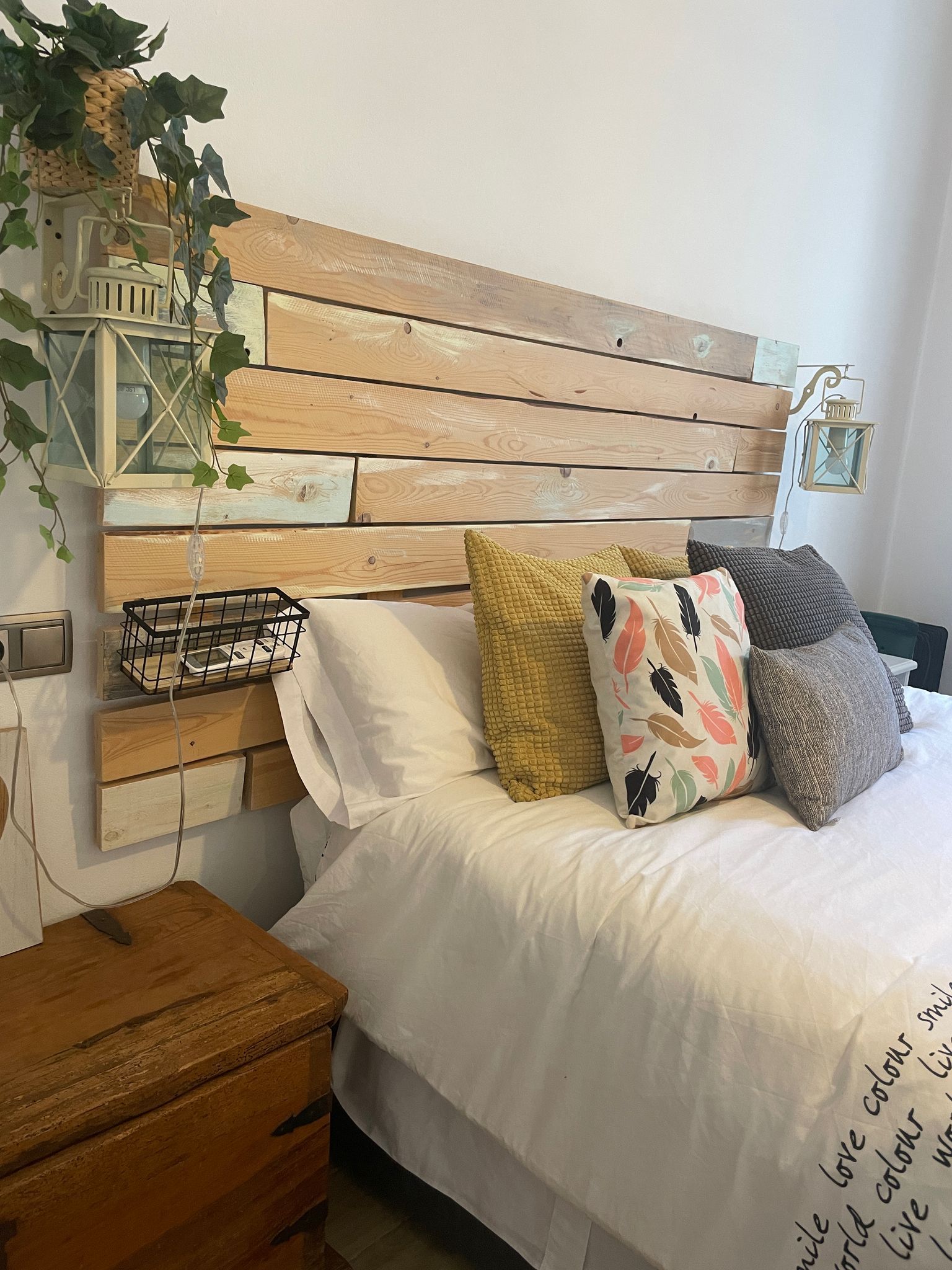 Una cama con cabecero de madera y almohadas en un dormitorio.