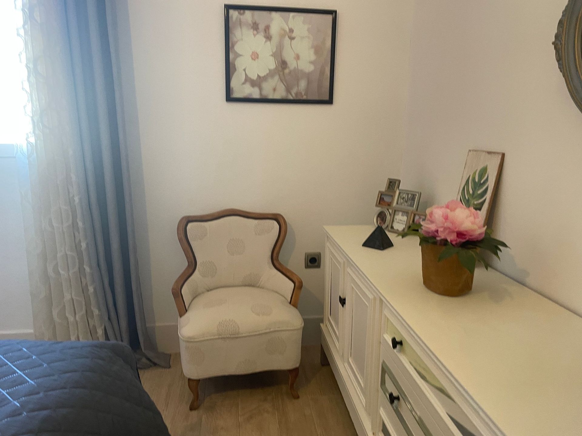 Hay una silla y una cómoda en la habitación.