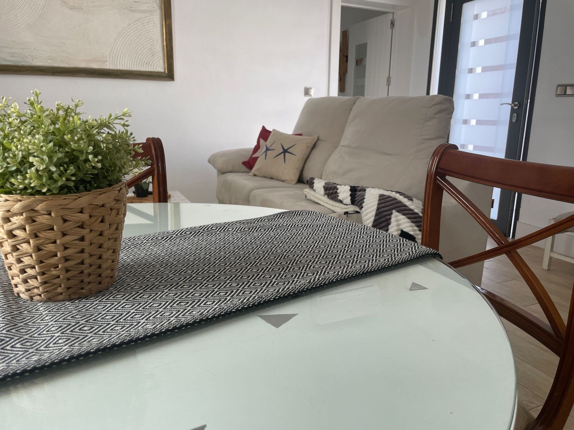 Una sala de estar con un sofá y una mesa con una planta encima.