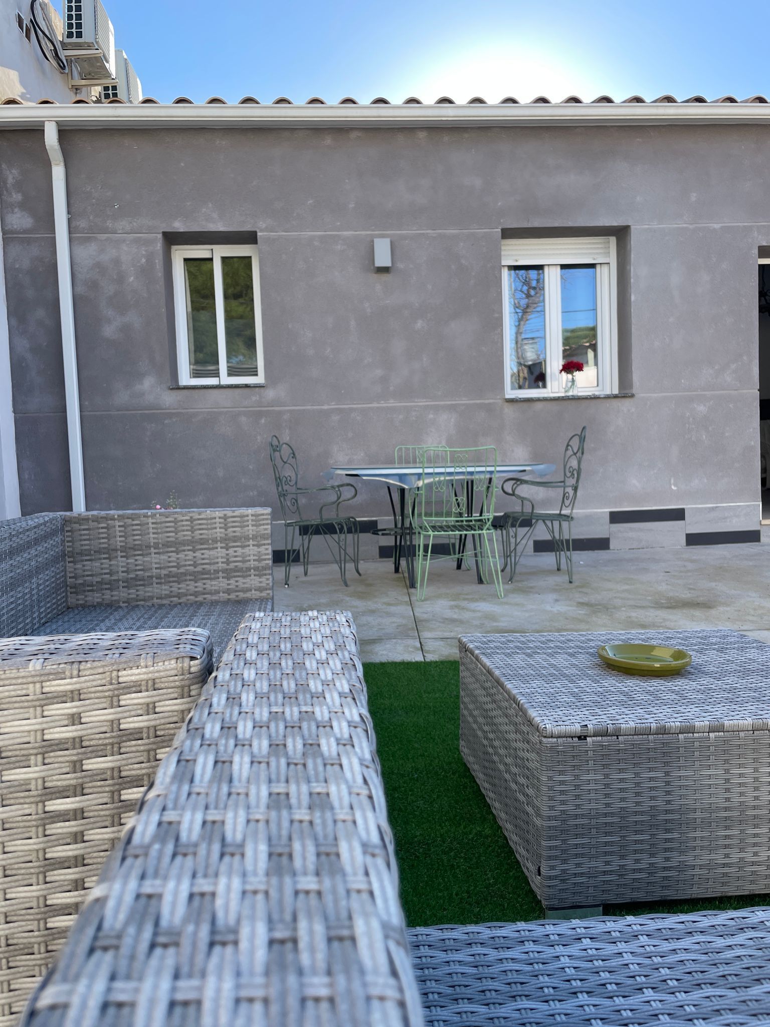 Un patio con una mesa y sillas frente a una casa.