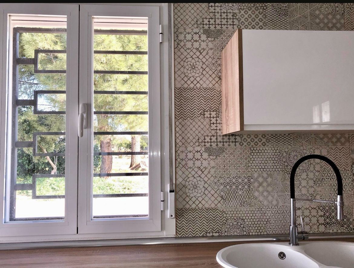 Una cocina con un fregadero y una ventana con una reja alrededor.