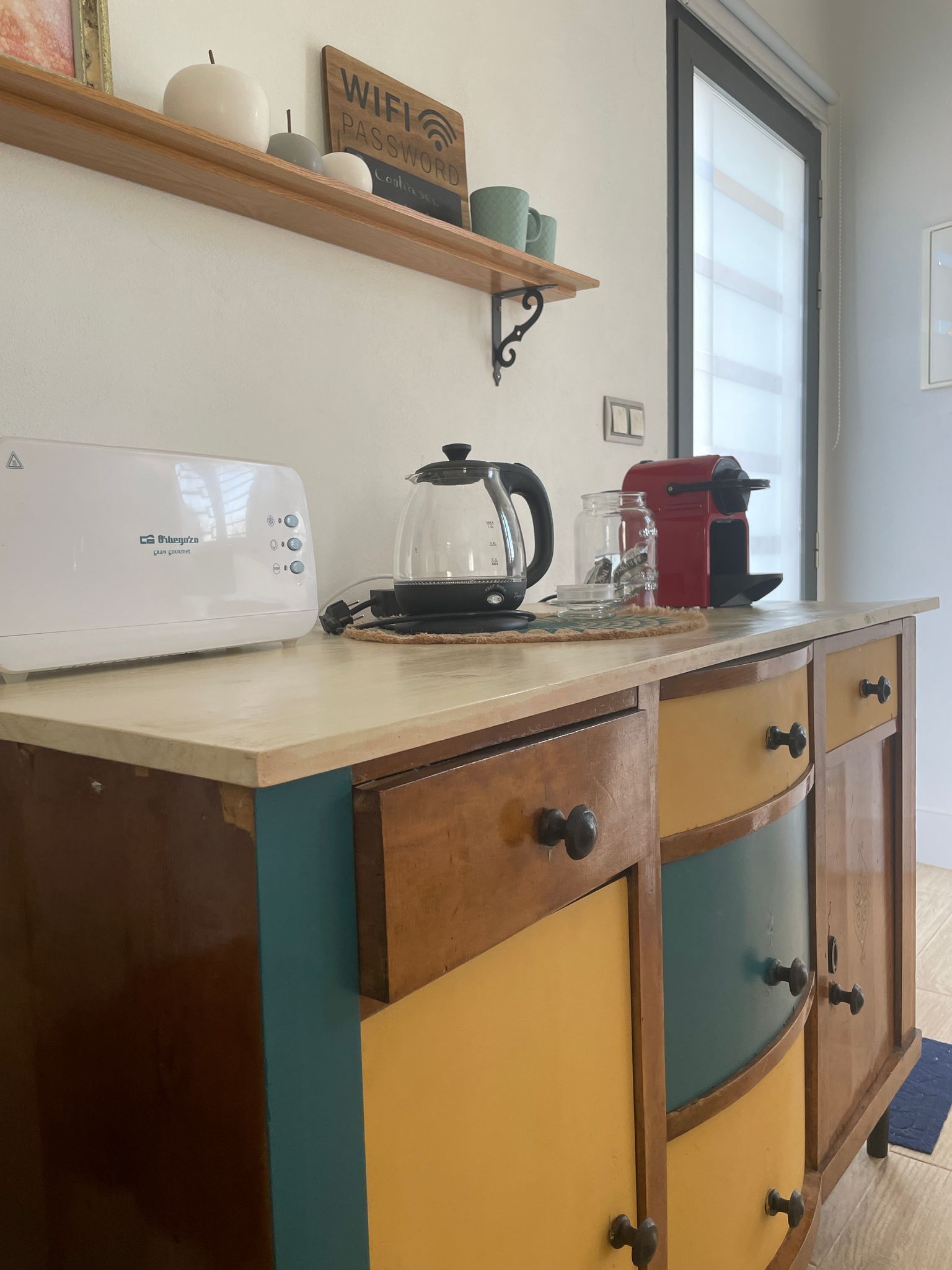 Una encimera de cocina con una tostadora y una cafetera encima.