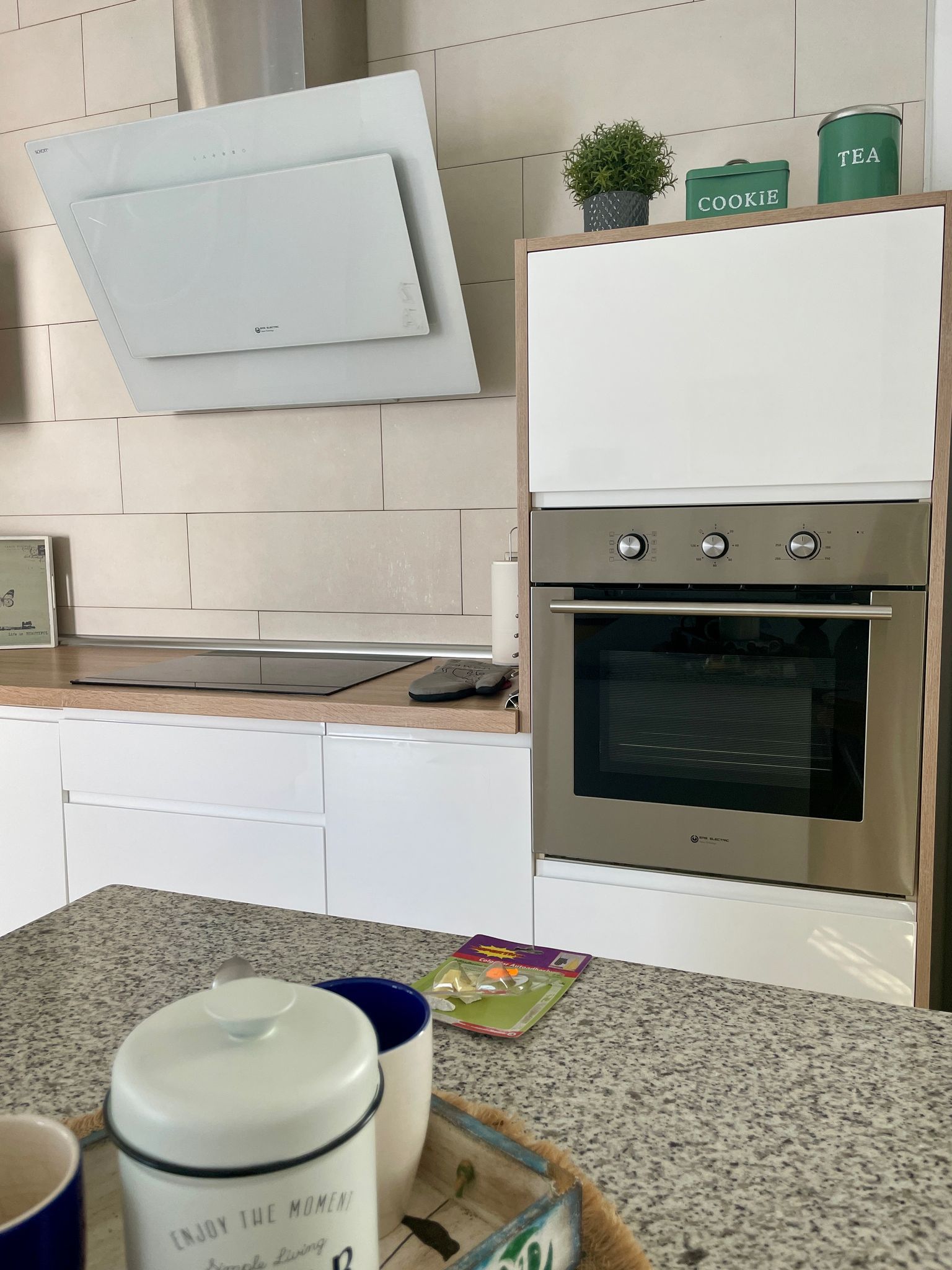 Una cocina con gabinetes blancos y un horno de acero inoxidable.