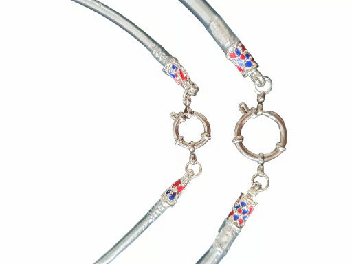 Collier en argent avec extrémités décoratives, accents rouges, bleus et blancs, et fermoir circulaire.