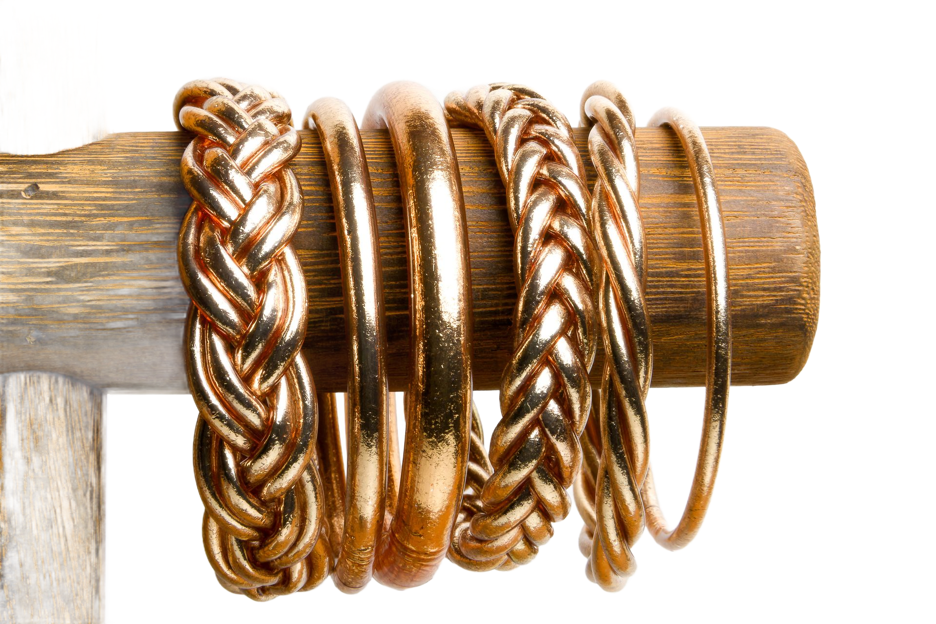 Bracelets en joncs bouddhistes présentés sur un présentoir en bois. Certains sont tressés, d'autres sont des anneaux pleins.