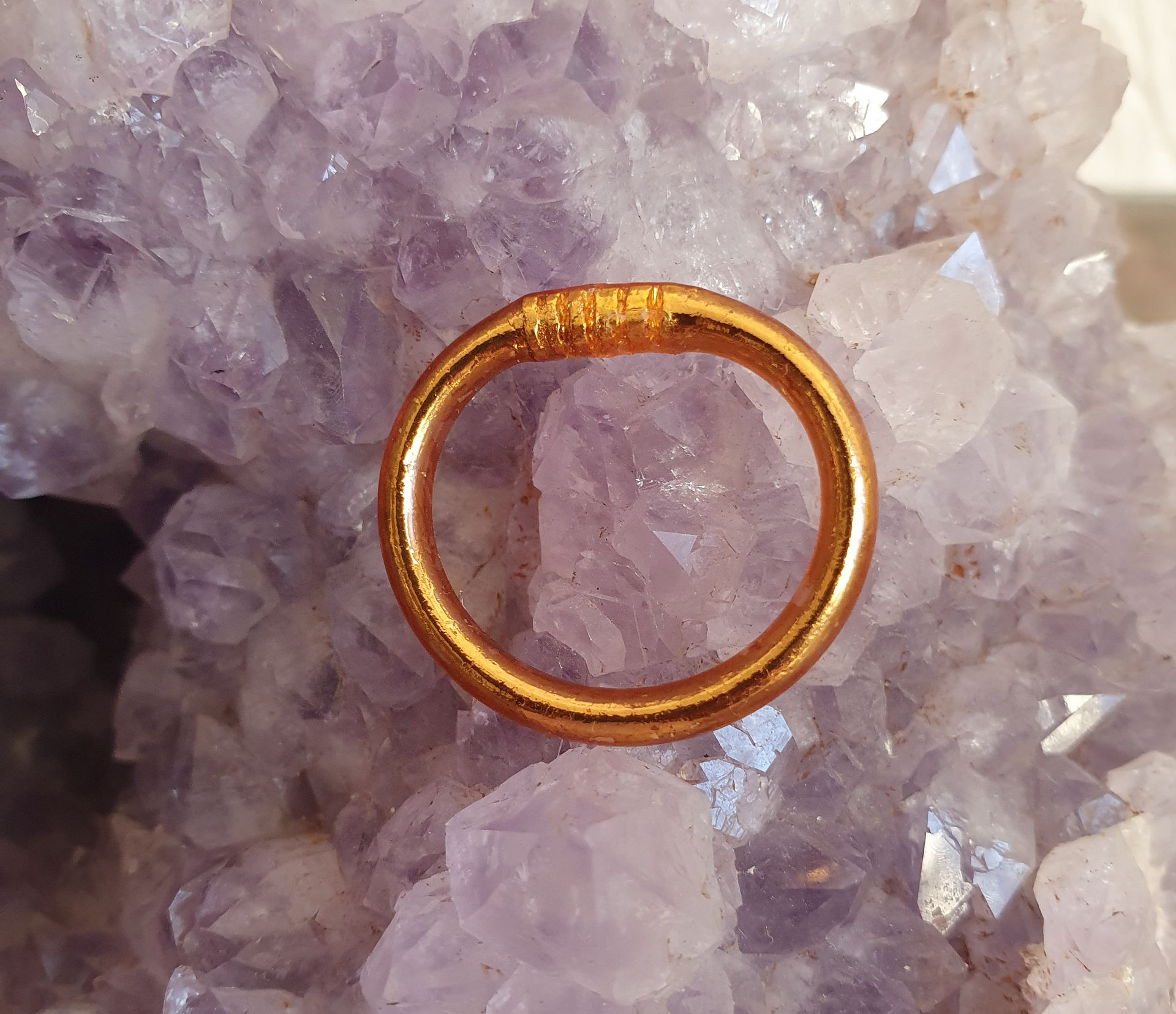 Bague en or sur un amas d'améthystes violettes.