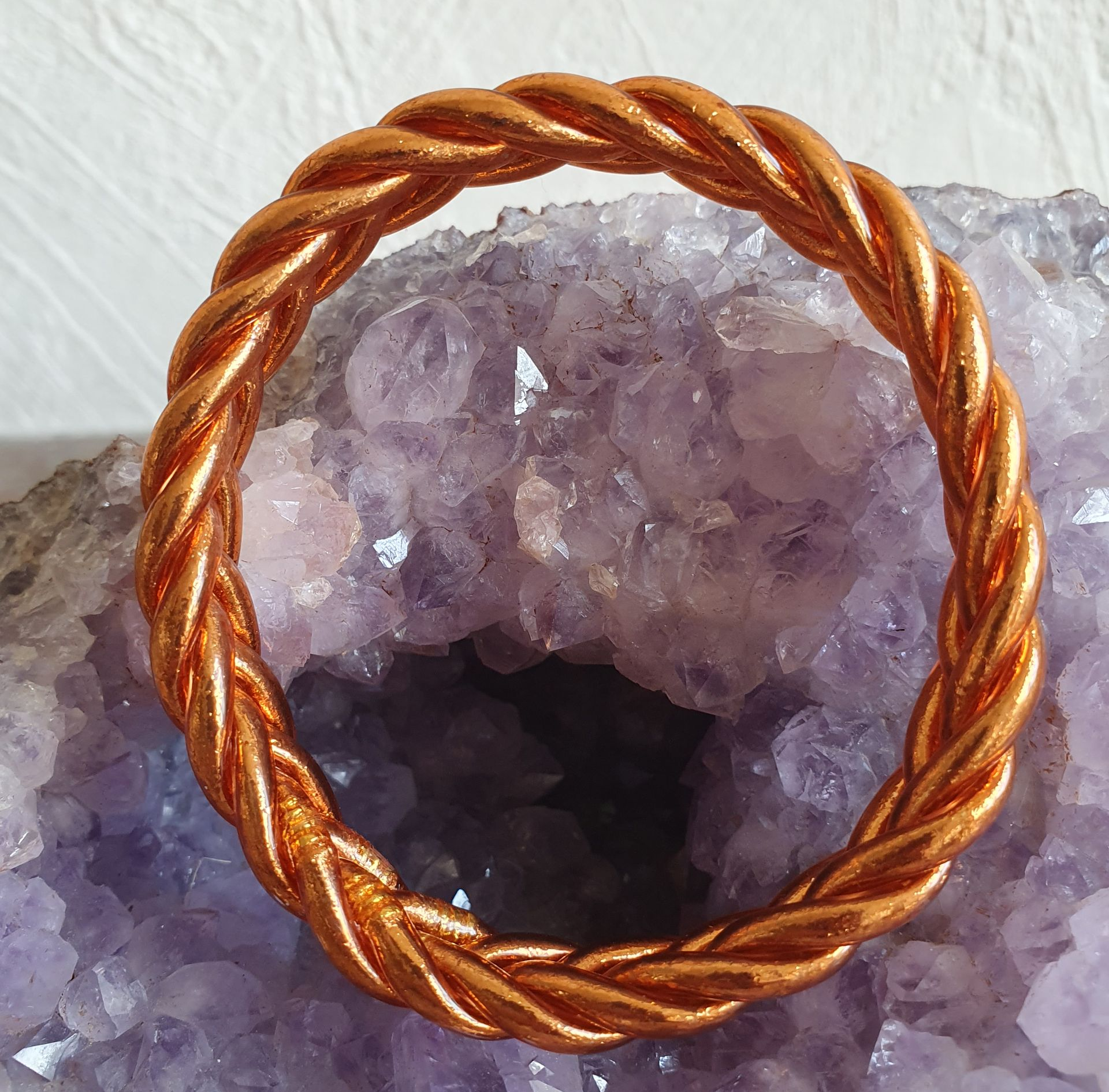 Bague tressée en cuivre sur un cristal violet.