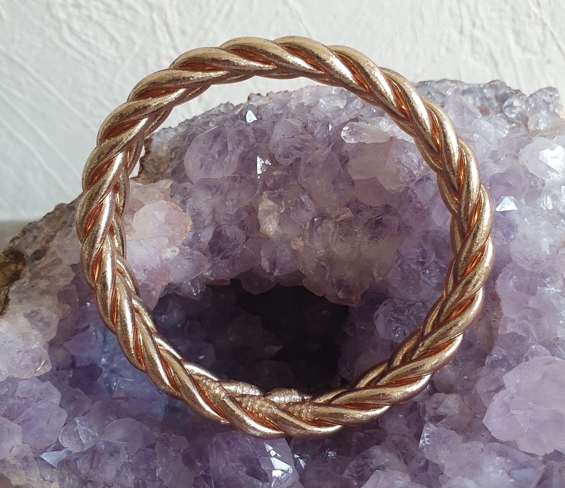 Bague tressée dorée sur une géode d'améthyste violette.