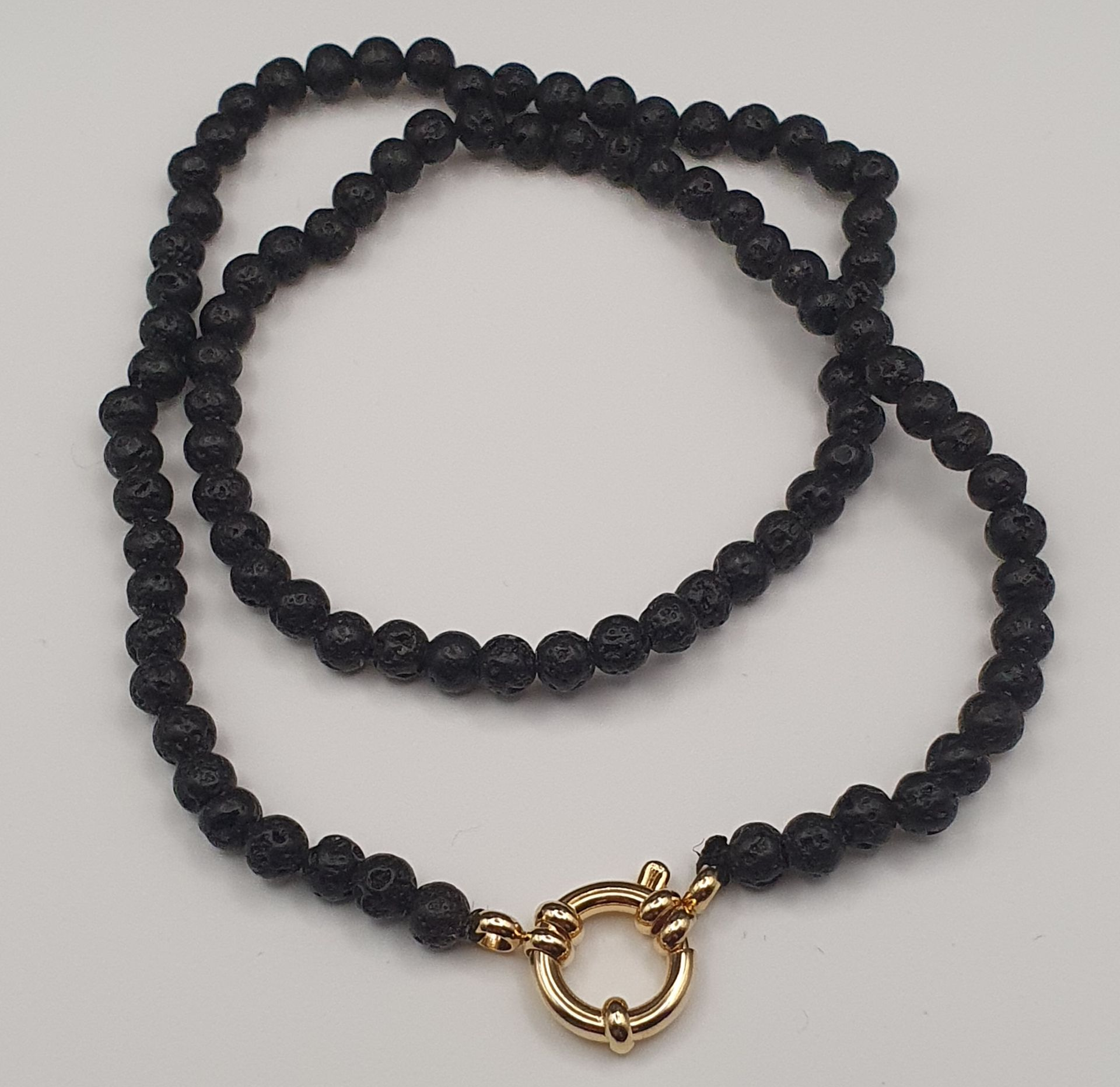 Collier de perles noires avec fermoir doré.