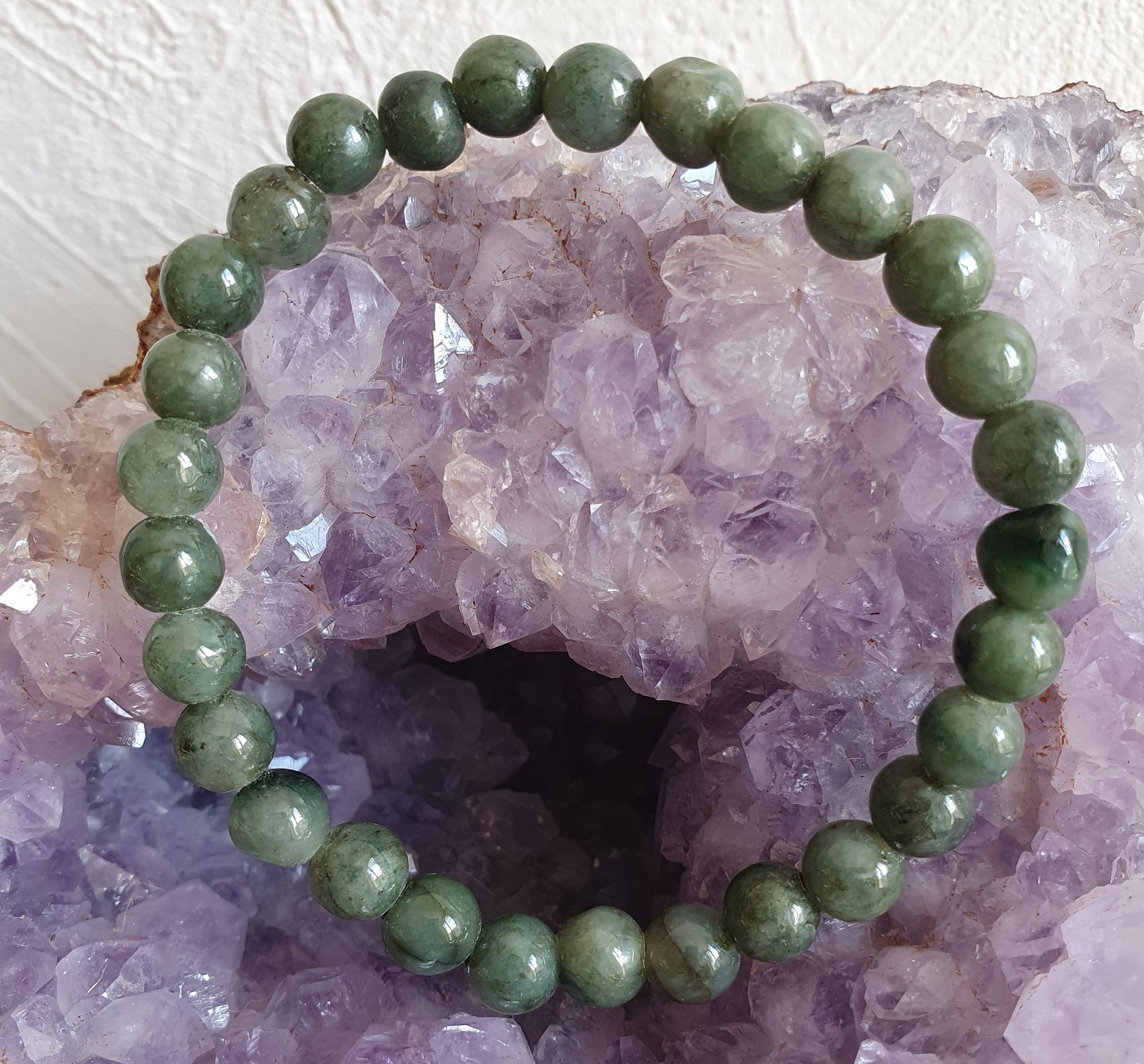 Un bracelet vert sur des pierres.