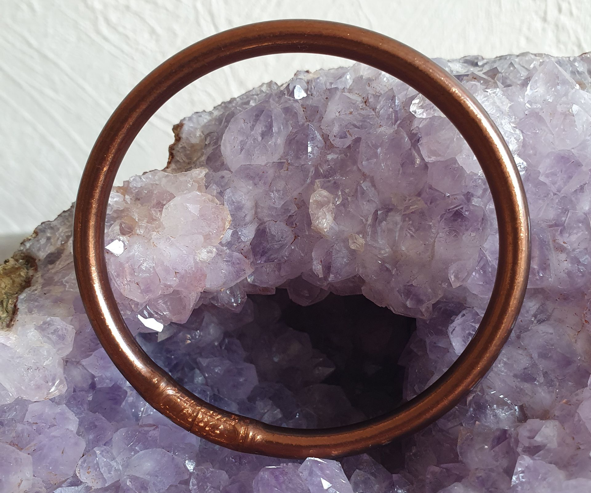 Bracelet Kumla posé sur une grande géode d'améthyste violette.