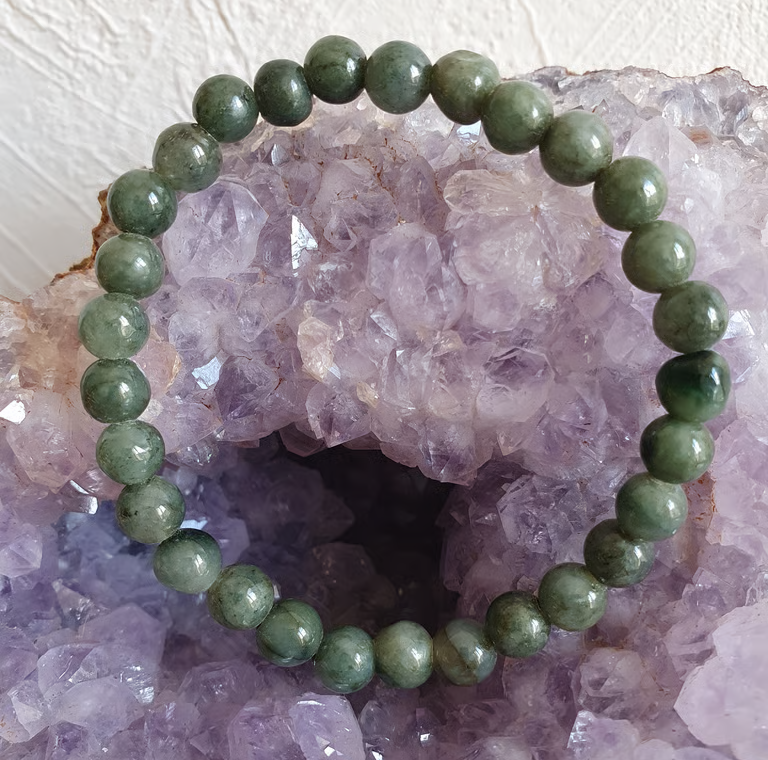 Bracelet de perles de jade vert sur une géode d'améthyste.