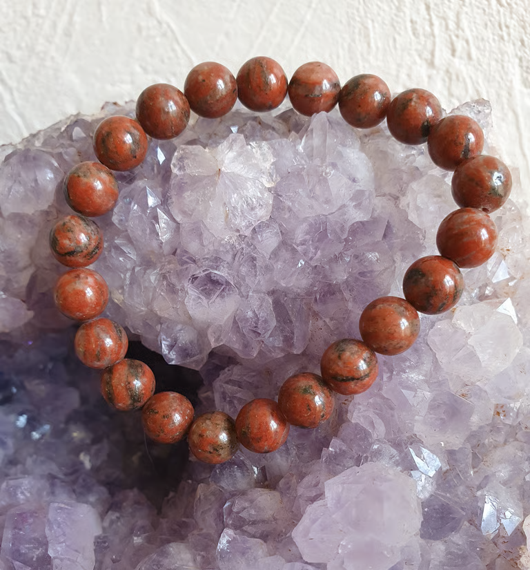 Bracelet de perles de jaspe rouge sur une géode de cristal violet.