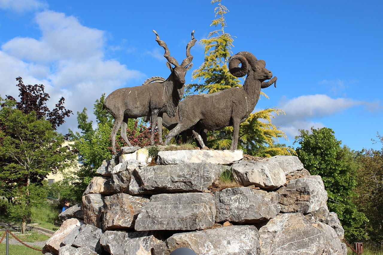 Una estatua de tres cabras paradas sobre una pila de rocas.