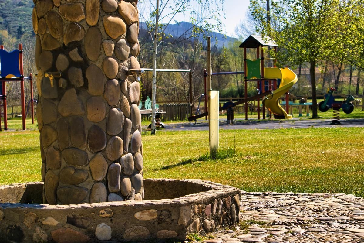 Un exuberante campo verde con montañas al fondo.