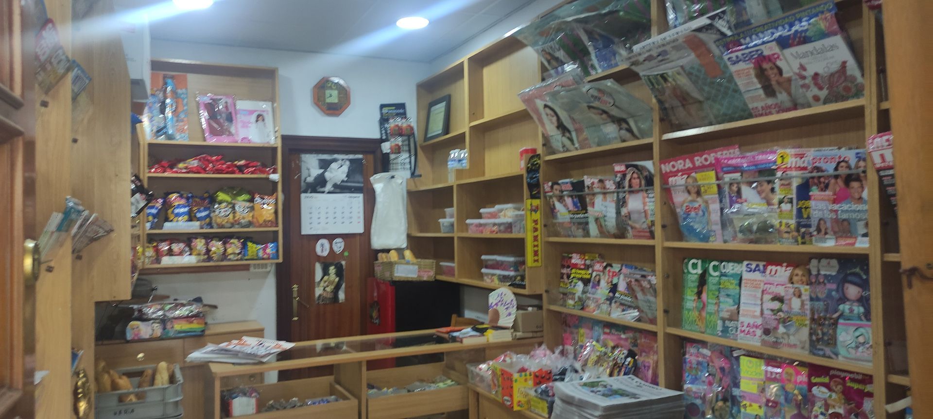 Una tienda llena de libros y revistas en los estantes.