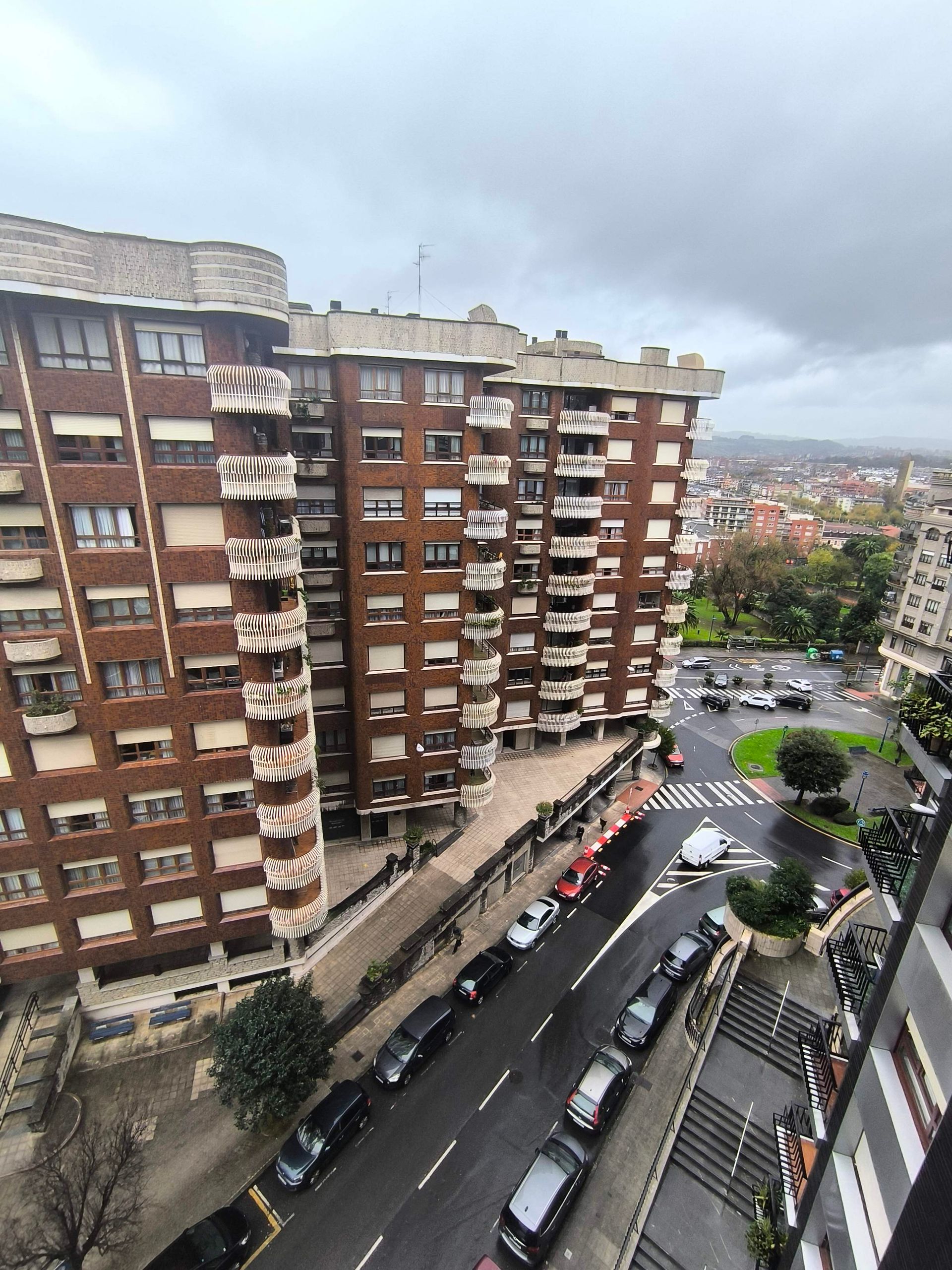 Una vista aérea de un edificio de ladrillo con autos estacionados frente a él.