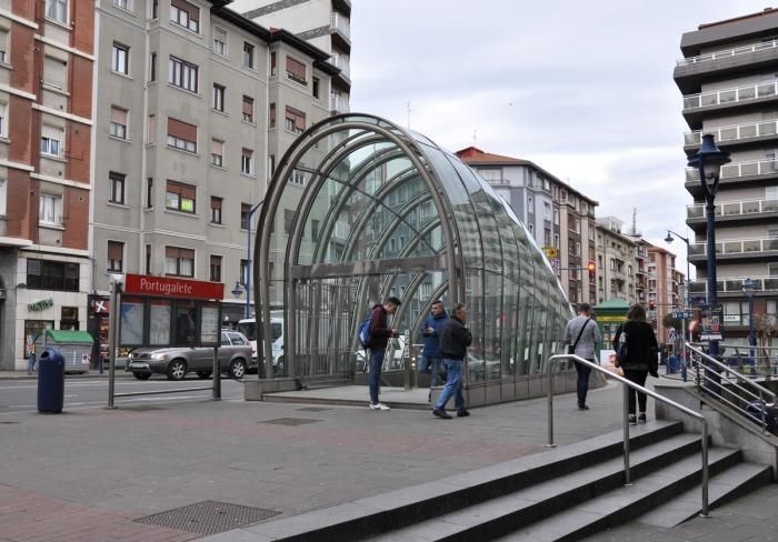 Un grupo de personas camina hacia un túnel de cristal.