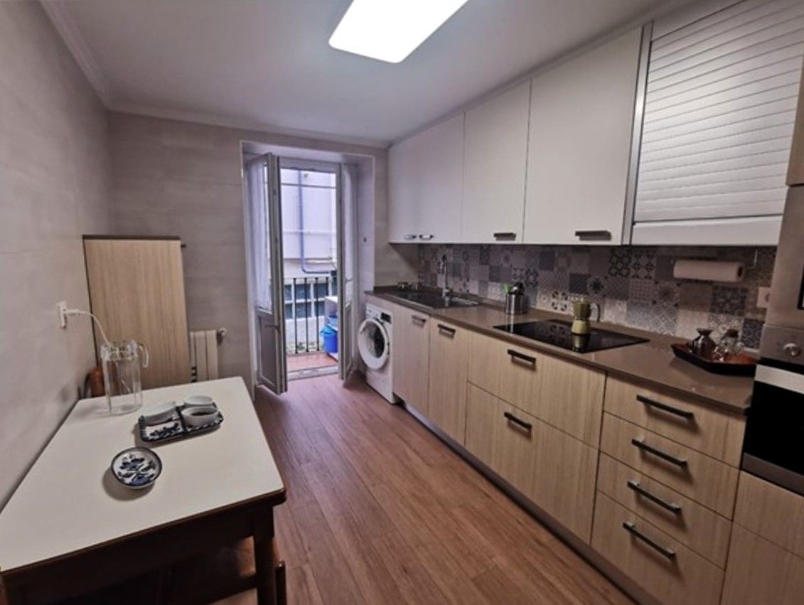 Una cocina con una mesa y una lavadora