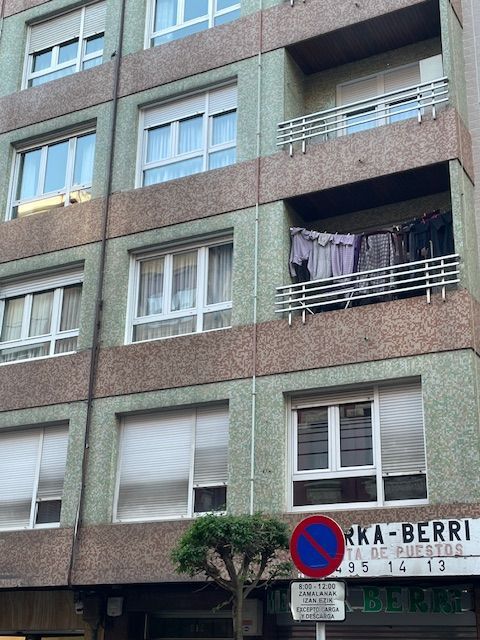 Un edificio con una señal de no estacionar enfrente.
