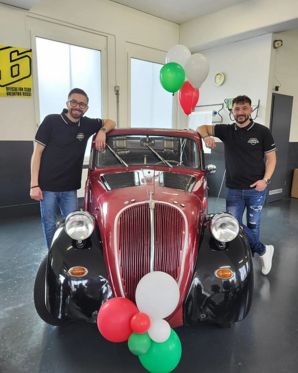 Zwei Mitarbeiter vor einem Oldtimert