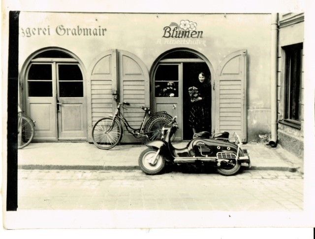 Ein mit Moos bedeckter Holzpavillon inmitten eines Waldes.