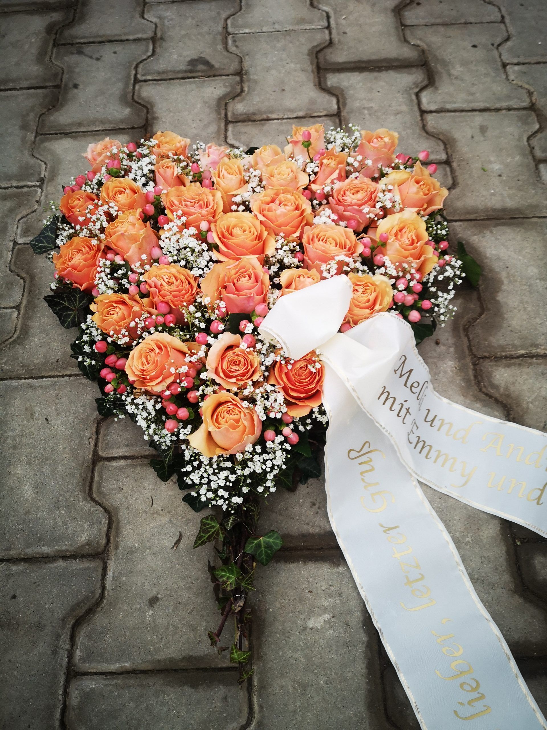 Trauergesteck mit orangen Blumen, Foto von Blumen Böswirth
